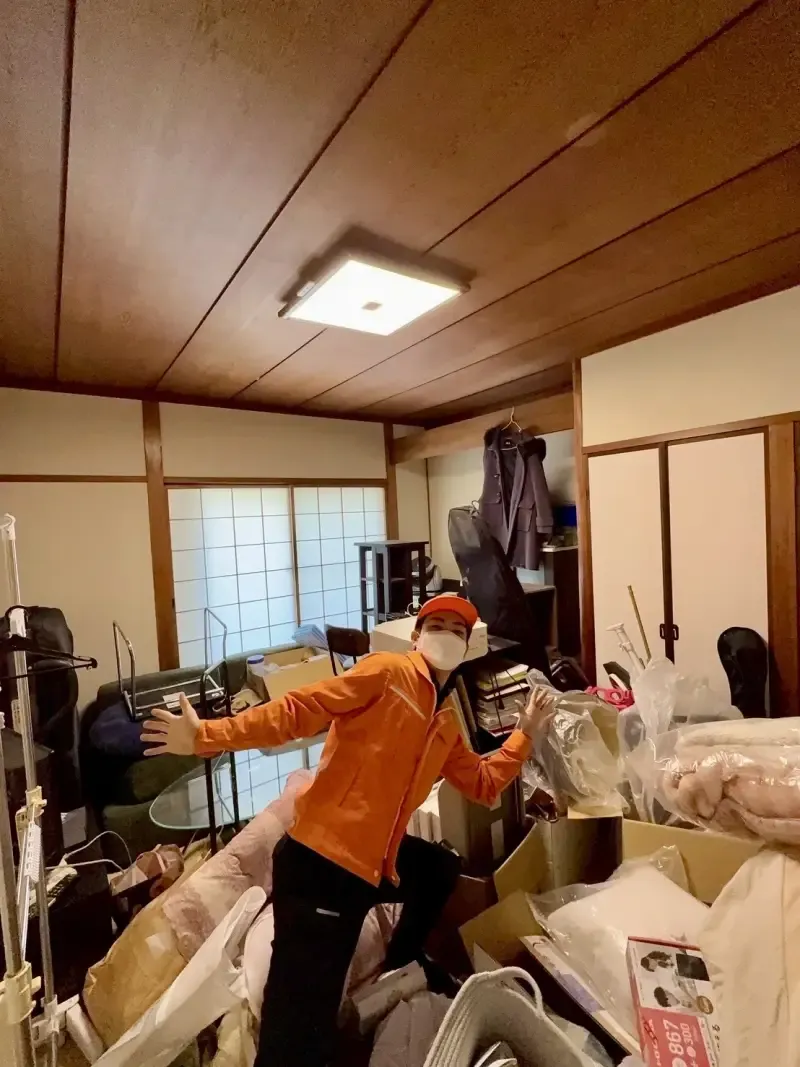 大量の荷物が積み重なった部屋の片付け前の様子